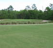 A marsh carry is followed by a large bunker that wraps around the right side of the 14th green at The Golf Club at Fleming Island.