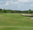Wind over the long par-3 sixth hole at Eagle Landing at Oakleaf Plantation blows left to right, pushing balls into water or sand.